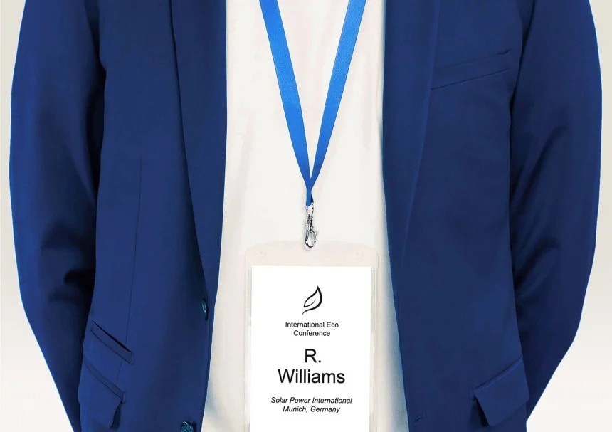 A man in a jacket with a lanyard with a name tag on the end