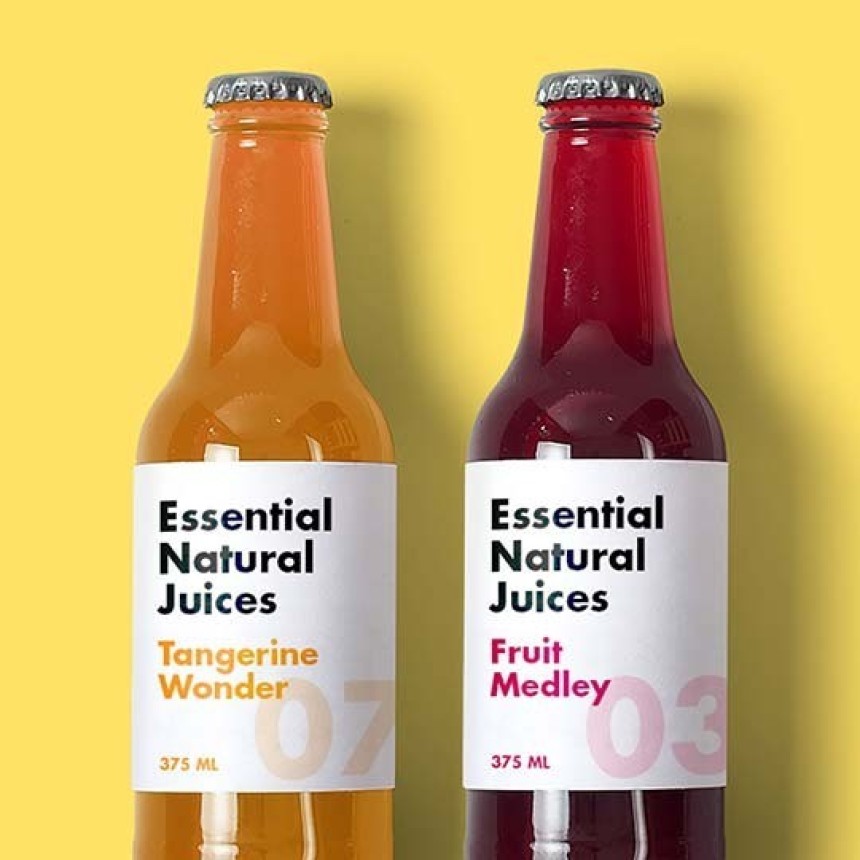A glass bottle with reddish juice labeled “Juice and Co” and “Breathe Easy” stands next to a similar bottle lying on its side. The label shows black wave graphics and ingredients: turnip, carrot, apple, spinach, parsnip, lemon, mint.